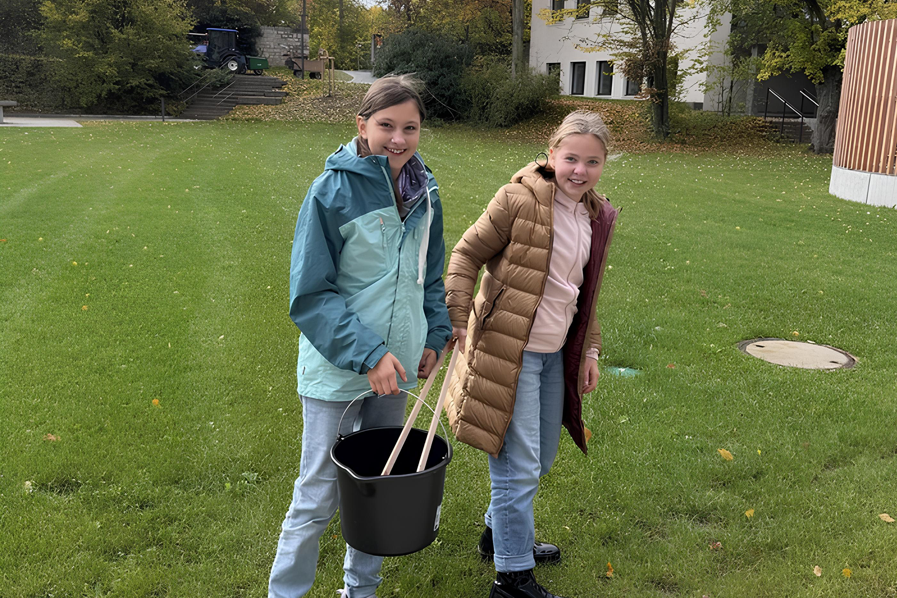 Zwei Schülerinnen mit Eimer und Greifzange