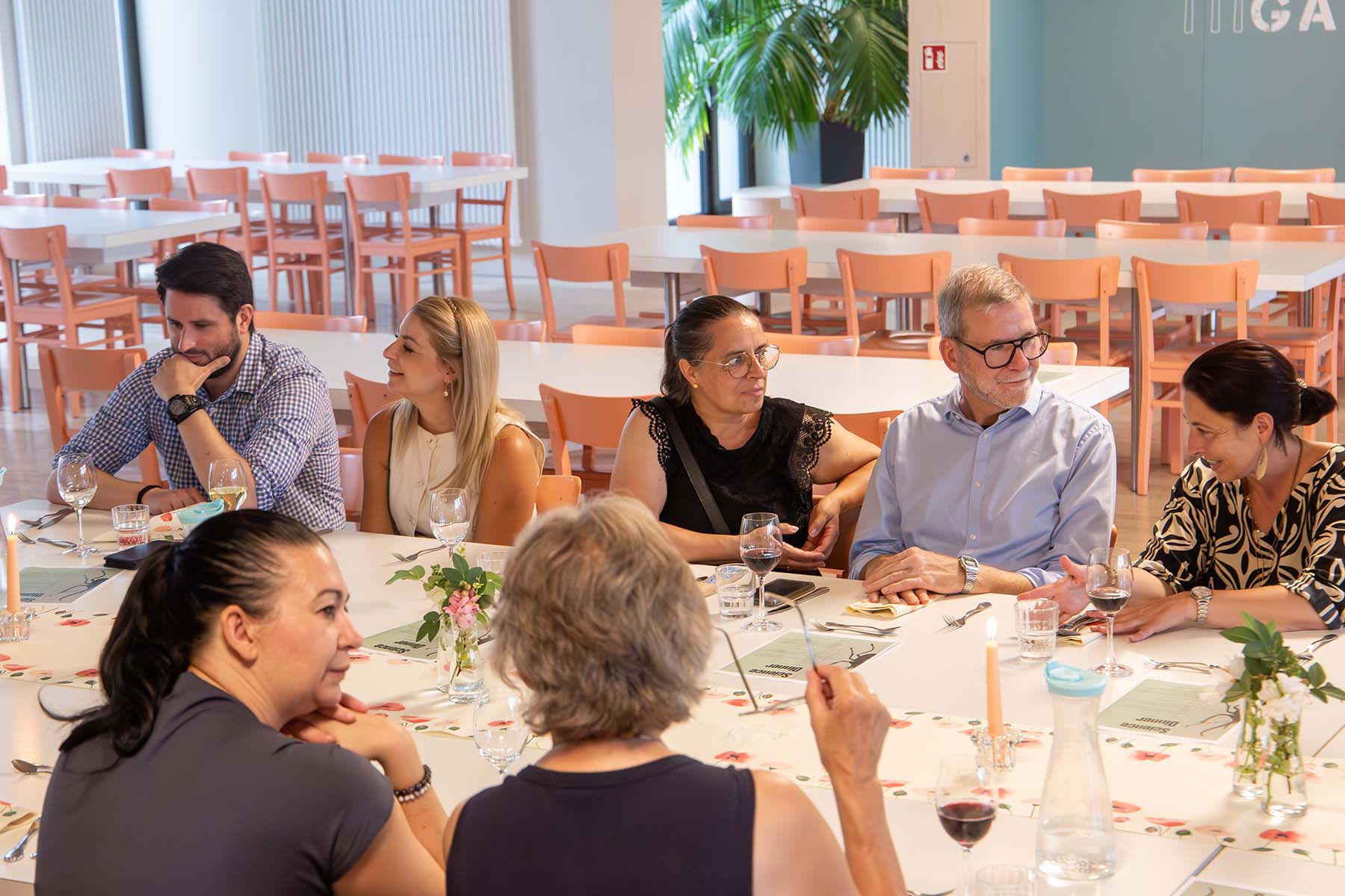 Menschen an der gedeckten Tafel, die sich unterhalten