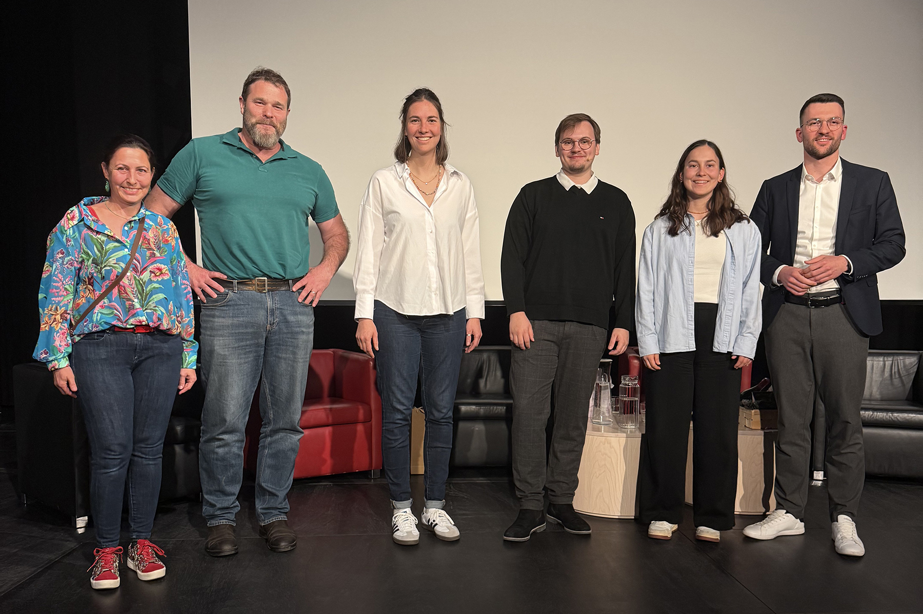 Gruppefoto der Teilnehmerinnen und Teilnehmer der Podiumsdiskussion auf der Bühne