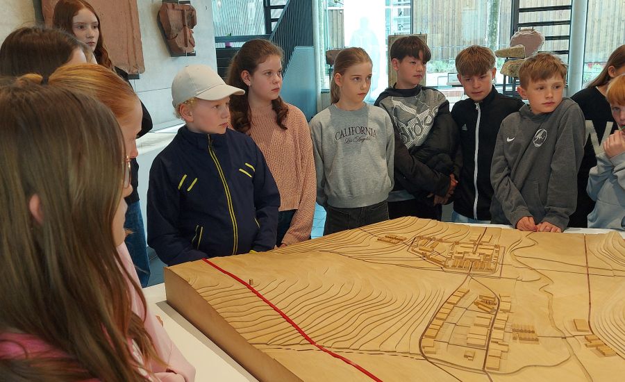 Schülerinnen und Schüler stehen vor einem Holzmodell