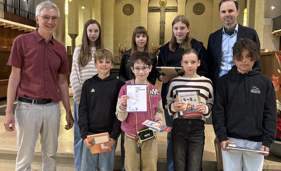 Gruppenfoto in einer Kirche, sieben Schülerinnen und Schüler mit Lehrer auf der linken und Schulleiter auf der rechten Seite