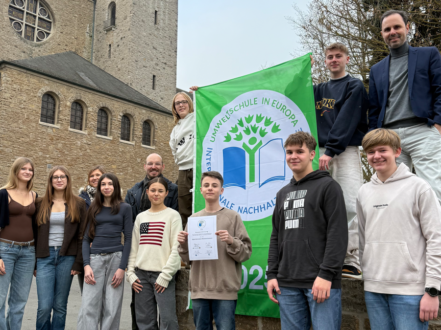 Schülergruppe und Schulleiter mit dem Logo der Umweltschule