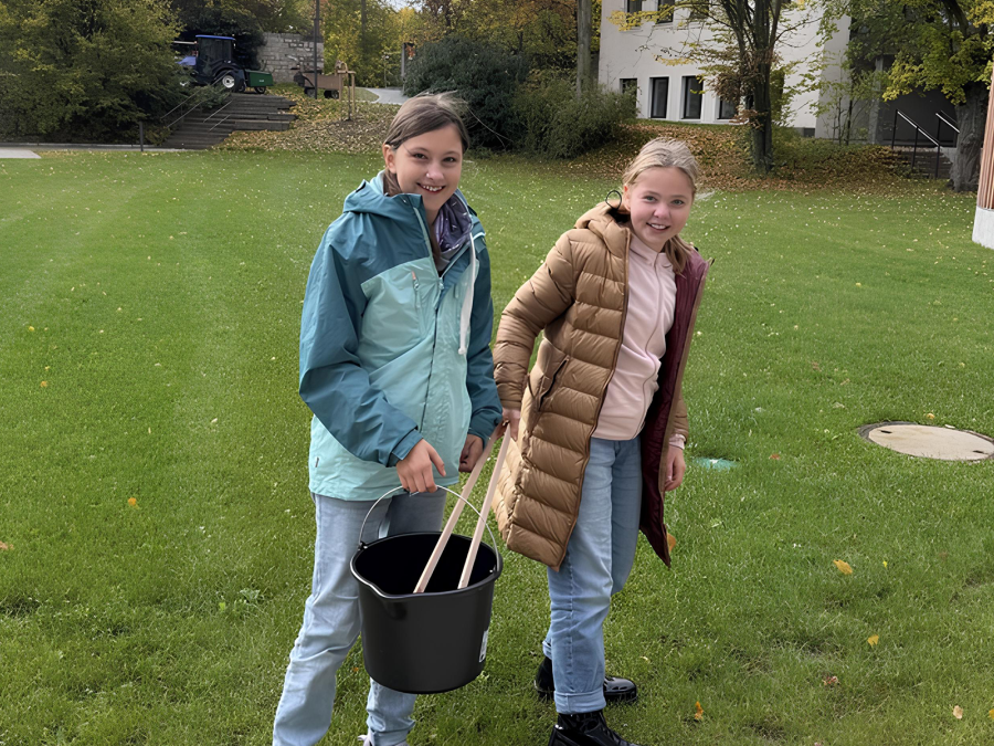 Zwei Schülerinnen mit Eimer und Greifzange