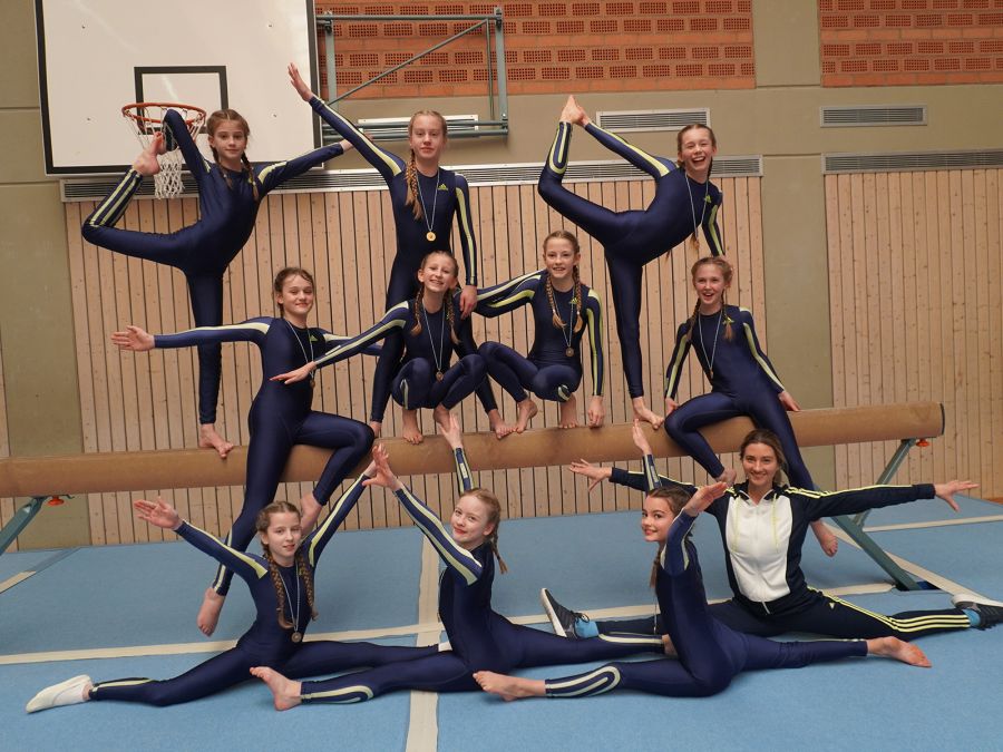 Gruppenfoto der Mädchenmannschaften vor dem Schwebebalken