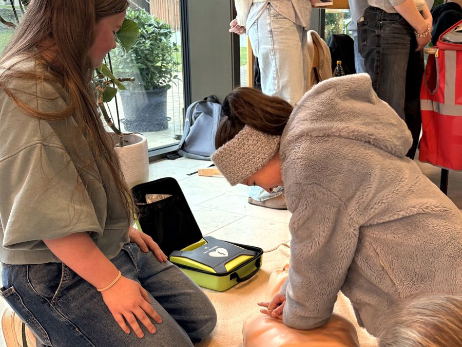 Schülerin übt erste Hilfe an einem Kissen