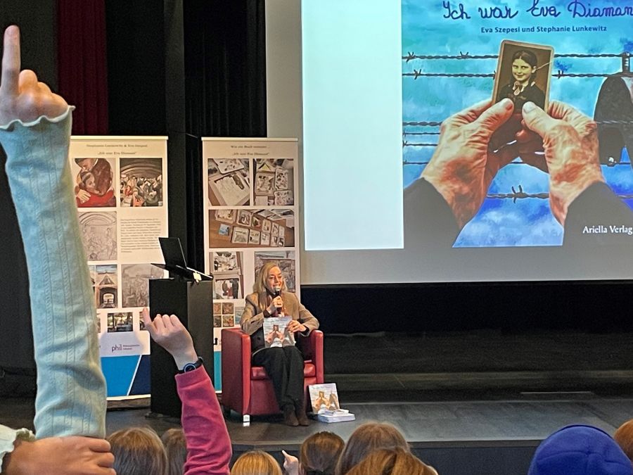 Eva Diamant sitzt auf der Bühne und beantwortet Fragen