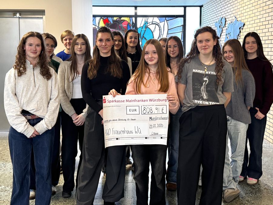 Gruppe von Schülerinnen mit einem großen Scheck