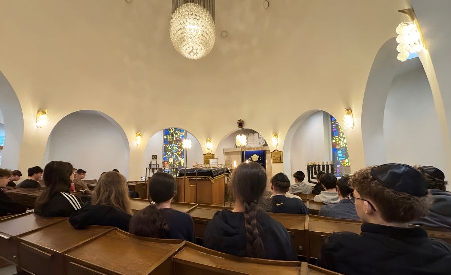Schülerinnen und Schüler sitzen in einem Raum der Synagoge