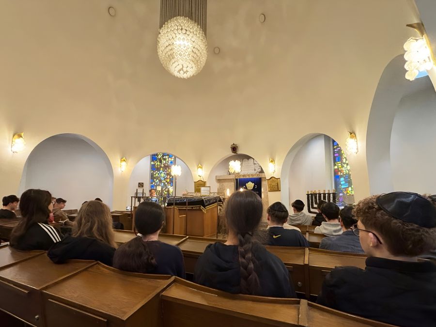 Schülerinnen und Schüler sitzen in einem Raum der Synagoge