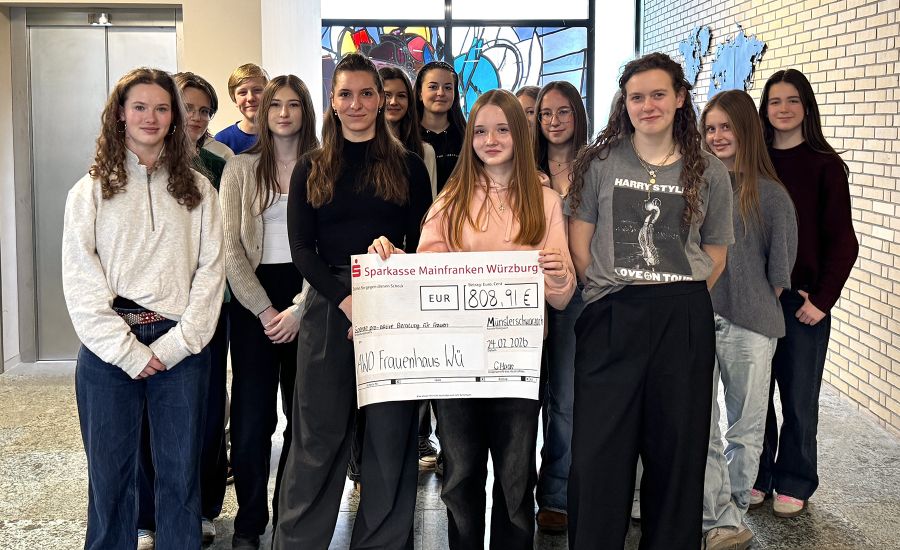 Gruppe von Schülerinnen mit einem großen Scheck
