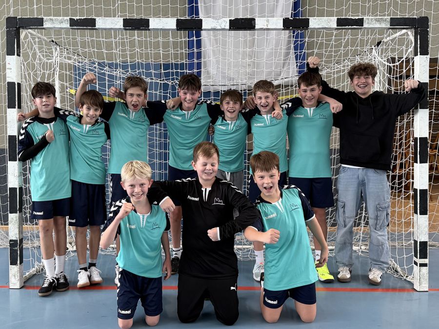 Gruppenfoto der Jungen-IV-Handballmannschaft vor dem Tor