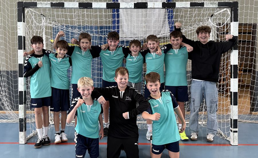 Gruppenfoto der Jungen-IV-Handballmannschaft vor dem Tor