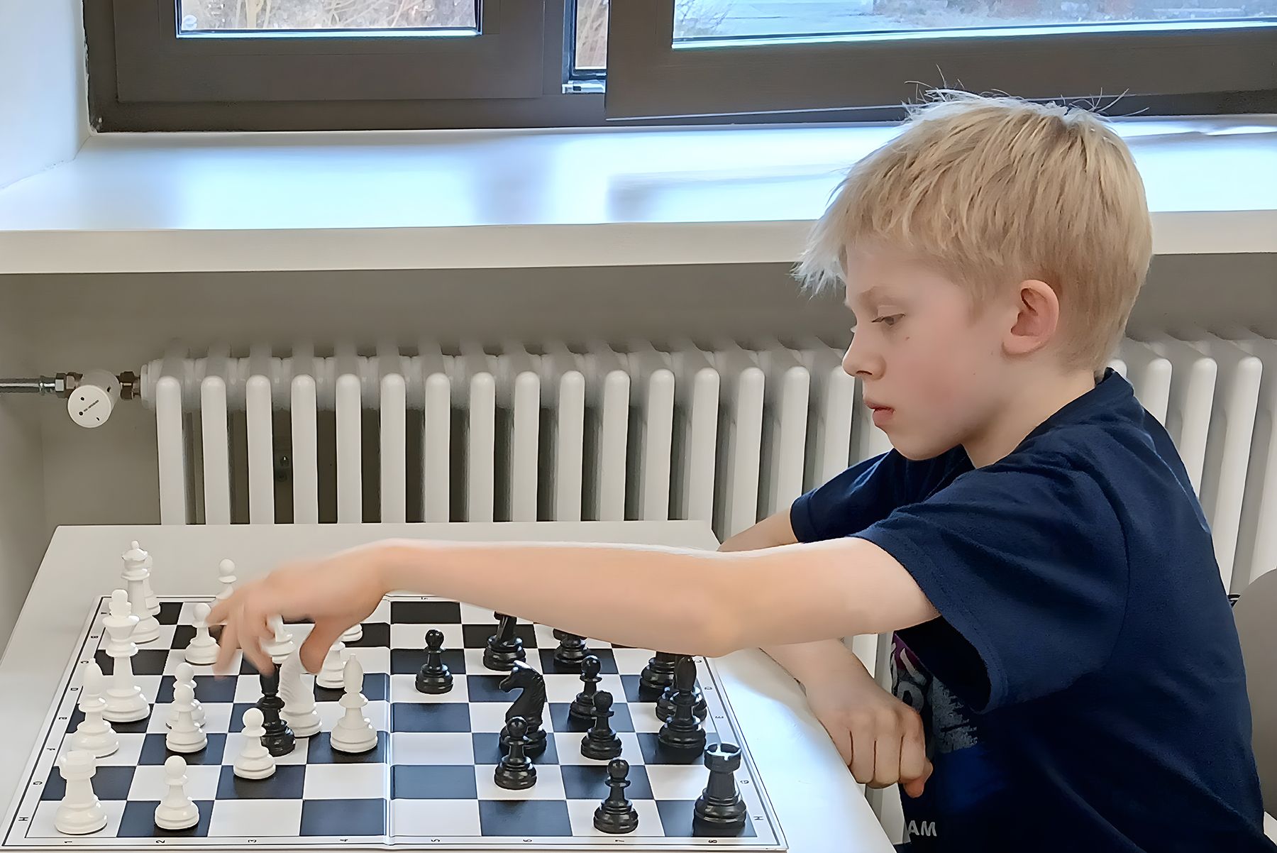 Blonder Junge am Schachbrett