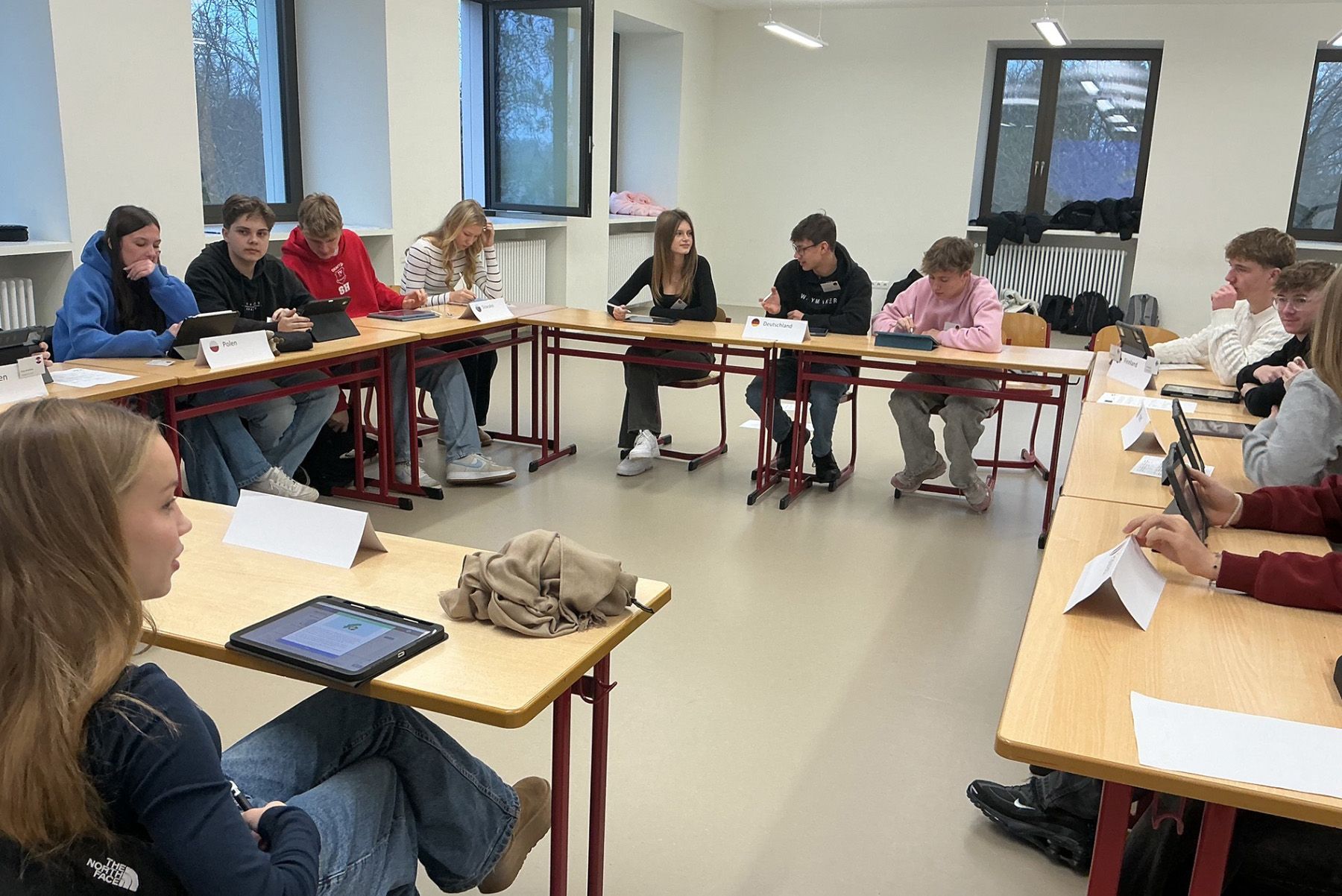 Blick von vorne auf die Tische mit Schülerinnen und Schülern