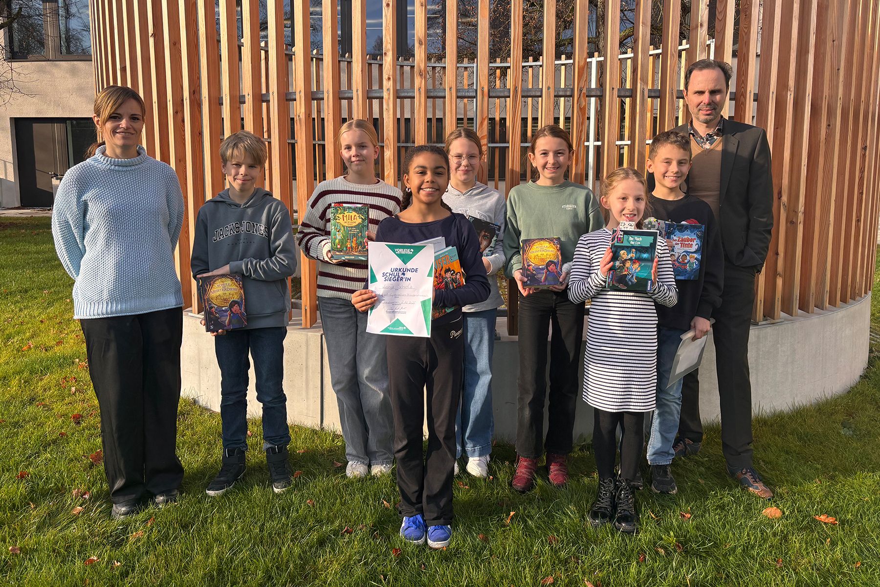 Gruppenfoto der Teilnehmer am Vorlesewettbewerb sowie die Siegerin