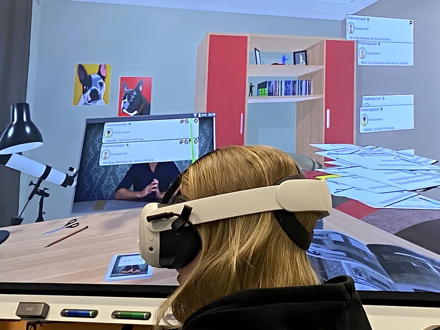 Mädchen mit VR-Brille vor großem Bildschirm