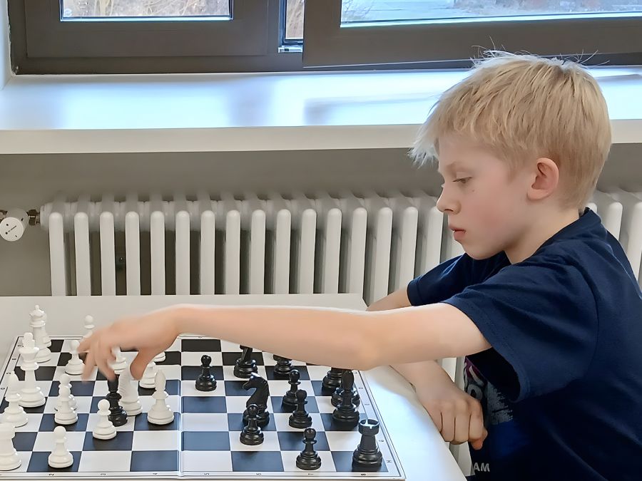 Blonder Junge am Schachbrett