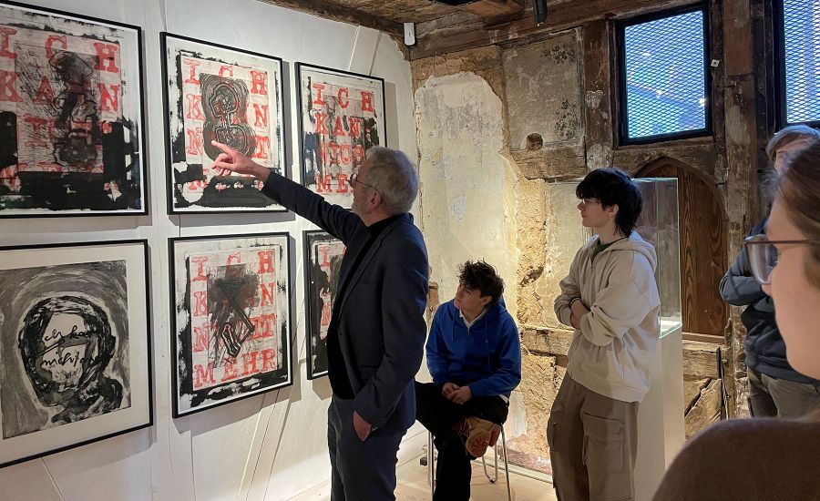 Ein Museumsmitarbeiter erklärt Schülern ein Bild